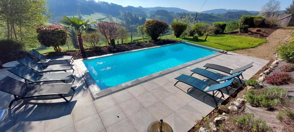 a swimming pool with lounge chairs next to it at Gezellige luxe caravan met zwembad in zuid- Bourgogne in Anglure-sous-Dun