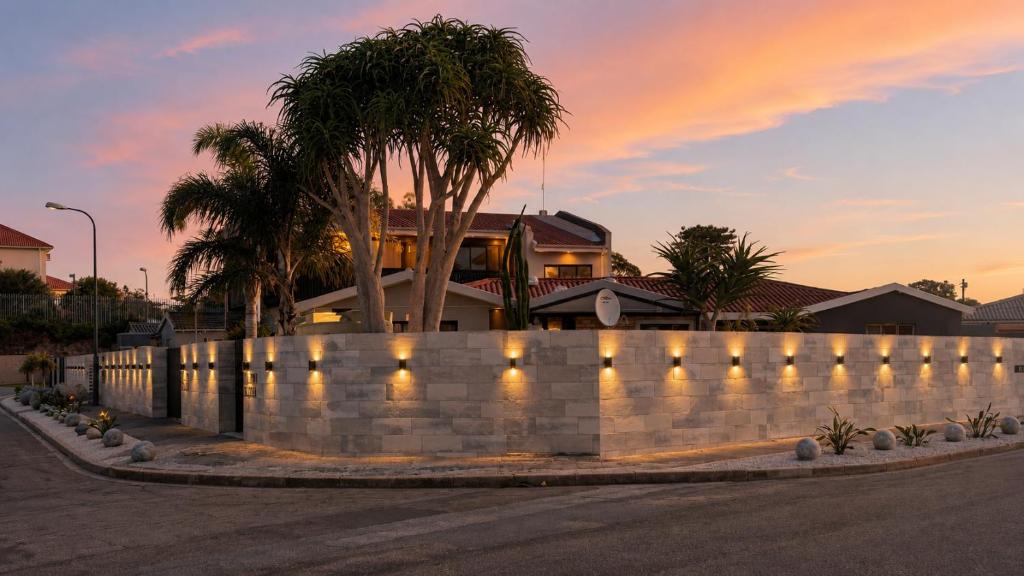 a retaining wall with lights in front of a house at Royal Palms Guest House in Port Elizabeth
