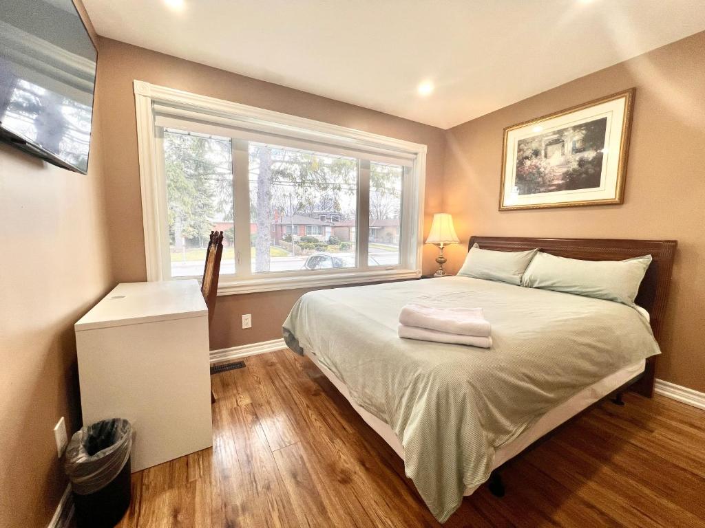 a bedroom with a large bed and a window at Renovated Rooms 10-min to Finch Subway Near Yonge St in Toronto