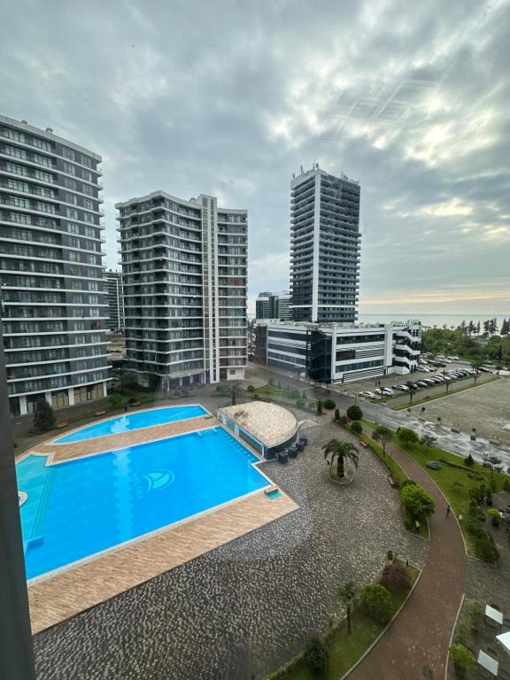 an overhead view of a swimming pool with tall buildings at Bright large apartment in White Sails in Batumi