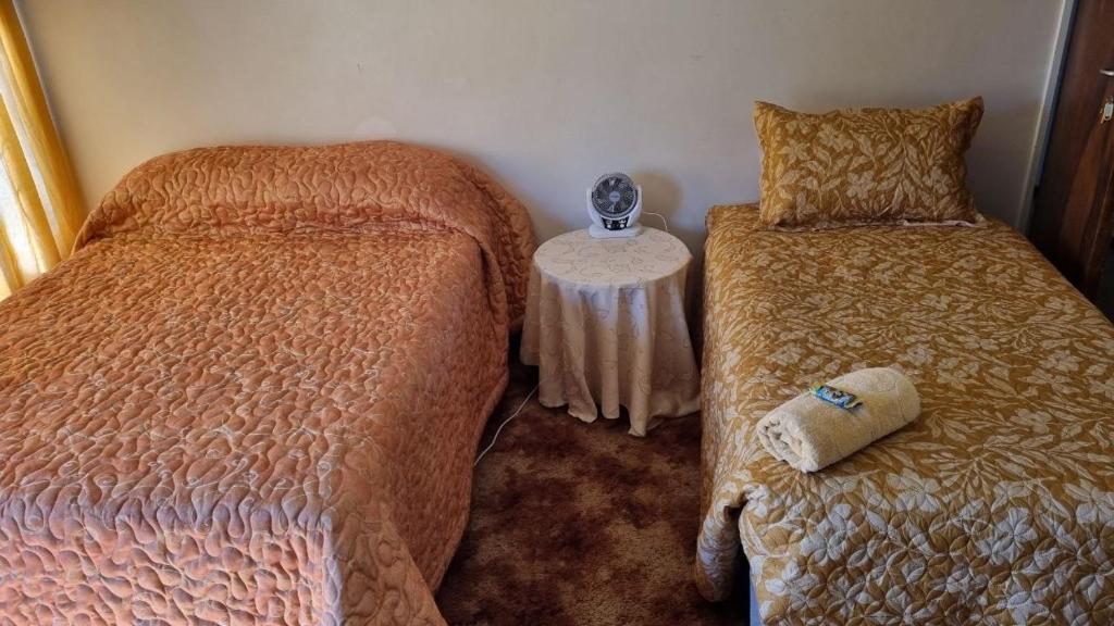 a bedroom with two beds and a small table at Highway Haven in Stilfontein