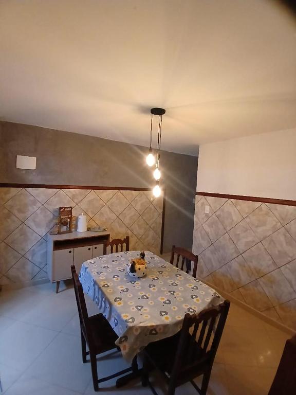 a dining room with a table and chairs and a kitchen at aconchego pe na areia in Ilhéus