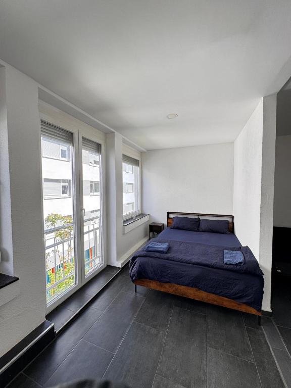 a bedroom with a bed and two windows at Marie Zimmer Zentral Bequem in Heilbronn
