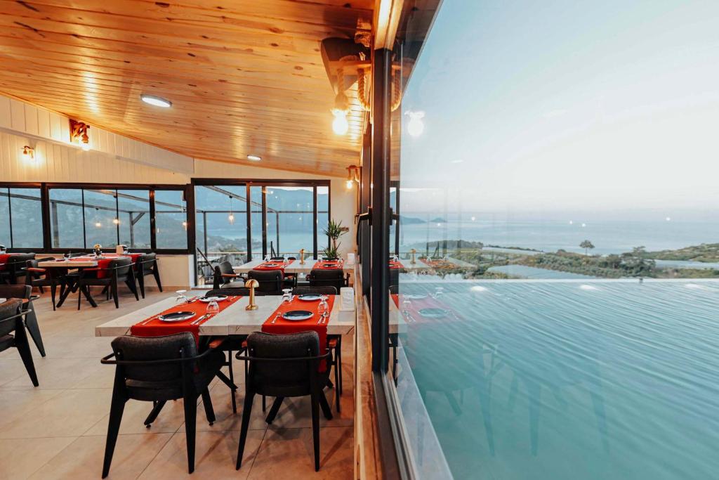 a restaurant with tables and chairs and a swimming pool at Seyr-i Mavi Bungalow in Mavikent