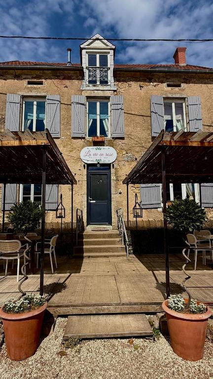 a building with a door and a table and chairs at La vie en rose in Brinay