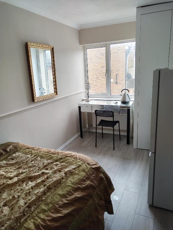 a bedroom with a bed and a desk and a mirror at Murston Double Room in Kent