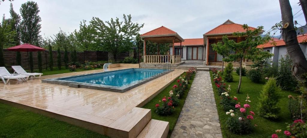 a backyard with a swimming pool and a gazebo at Mountain Hearth in Vǝndam