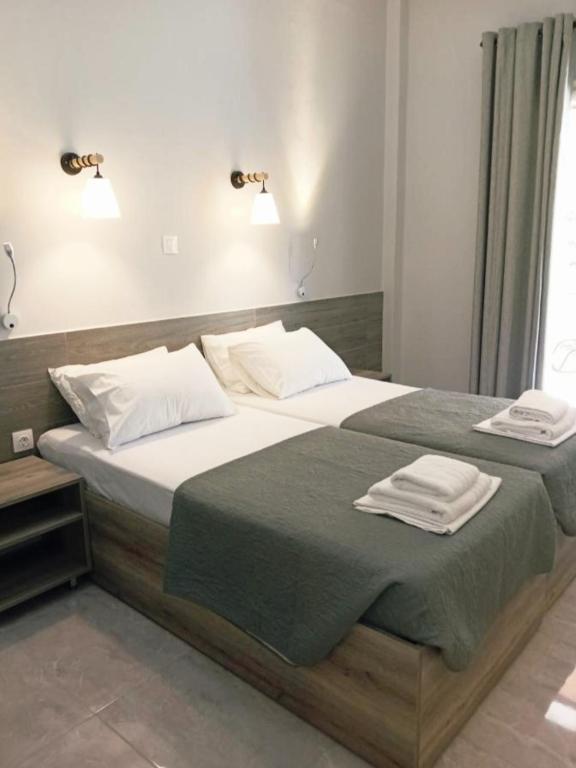 a bedroom with a large bed with two towels on it at Hermes in Agia Marina Aegina
