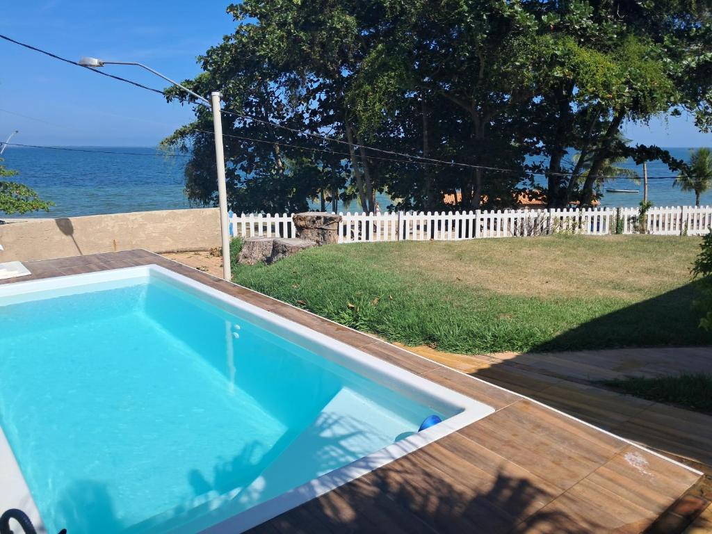 a swimming pool with a view of the ocean at Casa 4 quartos, 2 suítes, piscina e acessibilidade - Frente para a lagoa in São Pedro da Aldeia