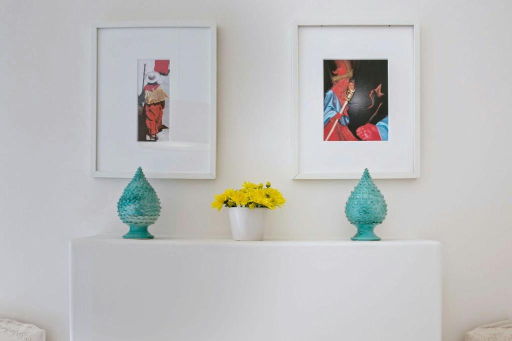 a white shelf with three pictures and vases on it at Domus Dejana in Gallipoli
