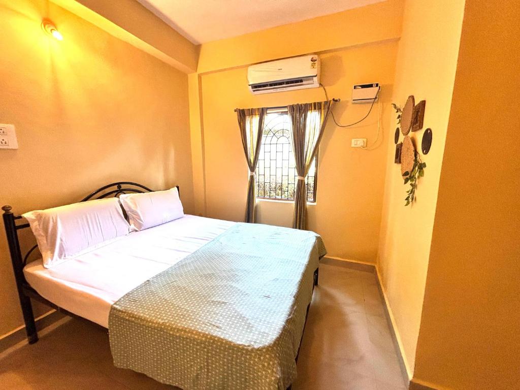 a small bedroom with a bed and a window at Seven Summers - Mandrem in Mandrem