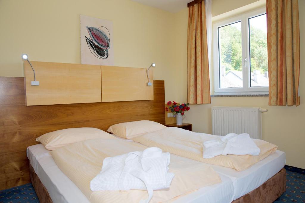 a bedroom with two beds with white towels on them at Gasthof - Landhotel Ernst in Untermühl