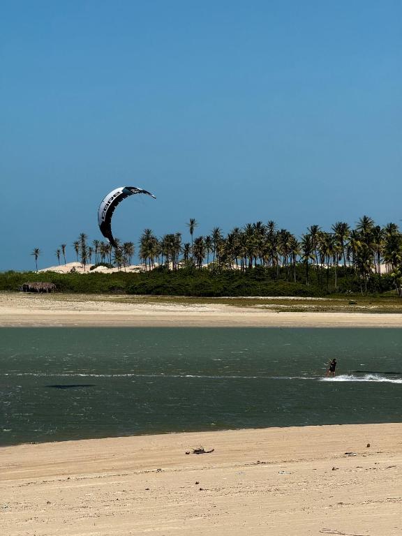 a person kite surfing in the water on the beach at Casita Beach House in Itarema
