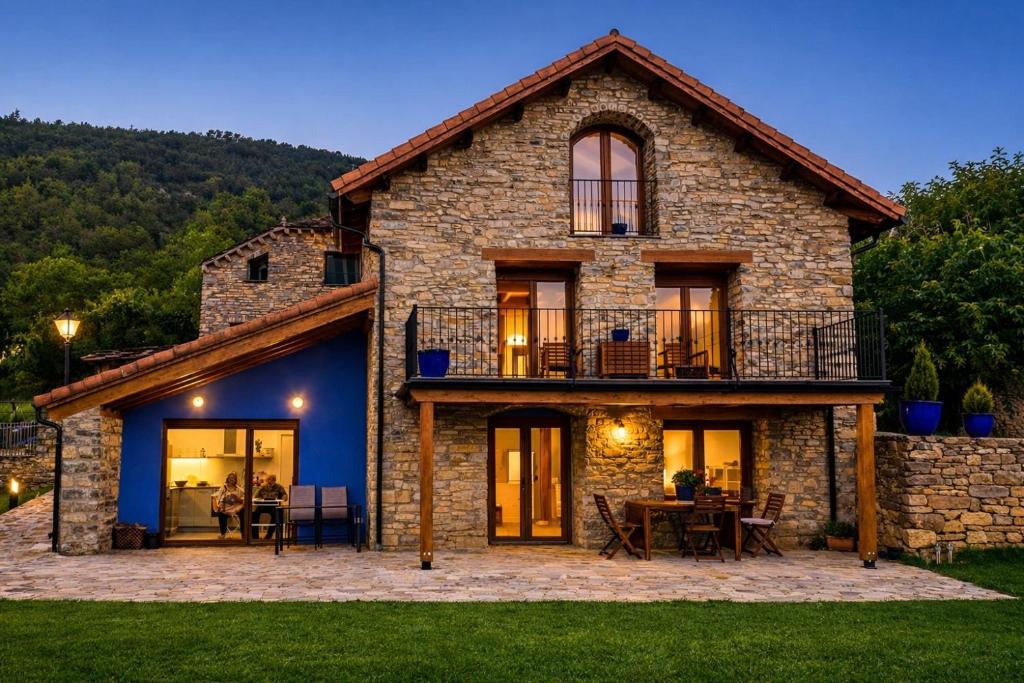 a large stone house with a deck and a patio at La Era de Lardiés in Lardiés
