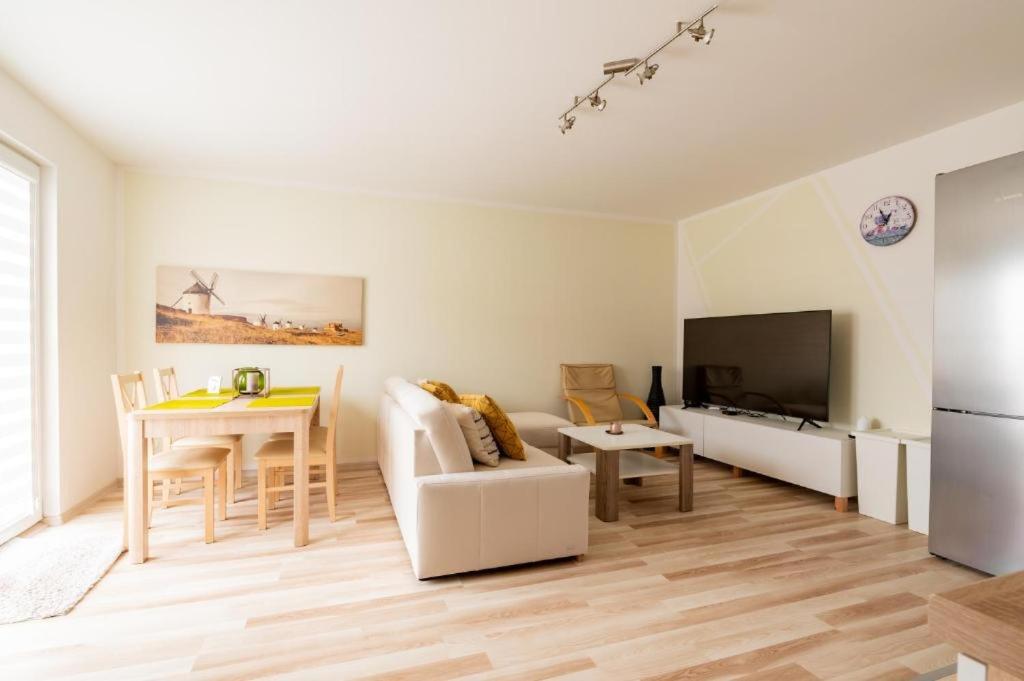 a living room with a couch and a table at Apartament Malinowy-Osiedle Malinowa 68, Zieleniewo in Zieleniewo