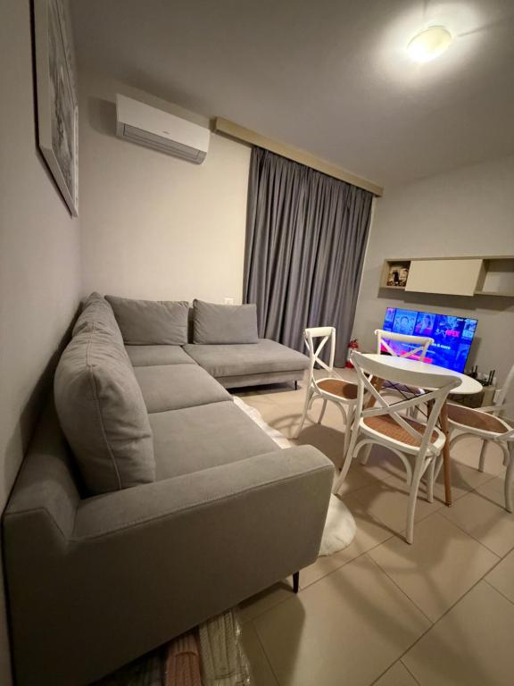a living room with a couch and a table at Pool View Private Apartment in Vlorë