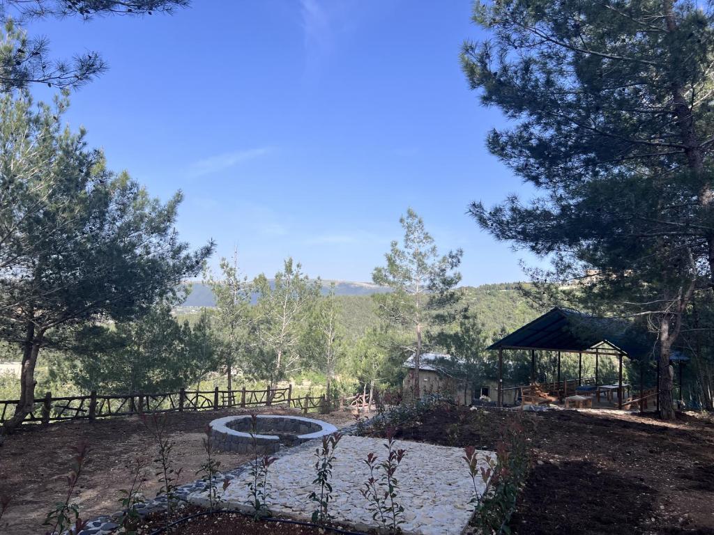 a garden with a pond and a fence and trees at Horizon Pines in Al Qbayyāt