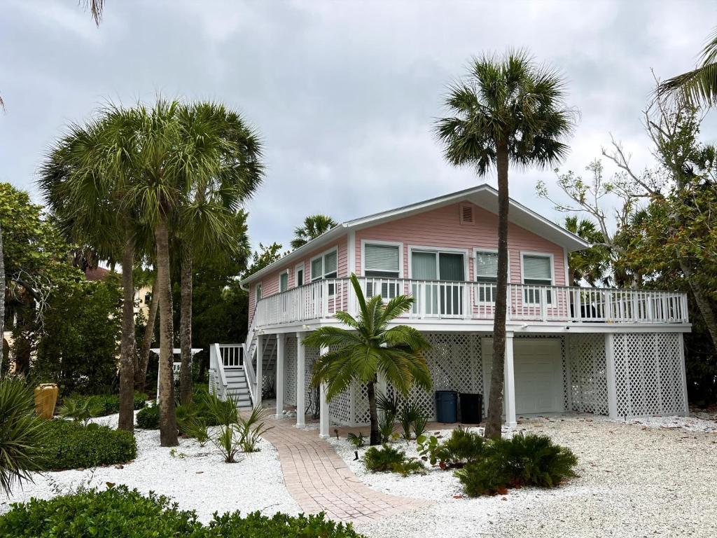 a pink house with palm trees on the beach at Pink Shell Sanibel in Sanibel
