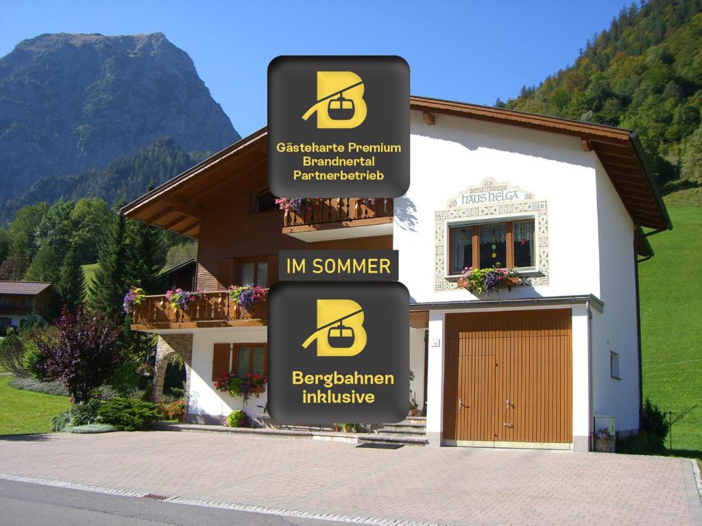 a sign that reads im summer and a house at Haus Helga in Brand
