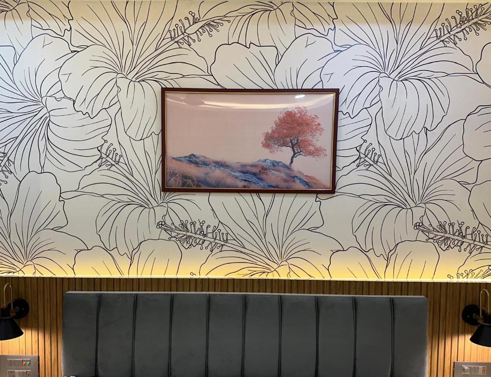 a painting of a tree on a wall with flowers at Hotel silver star in Kishanganj Bazar