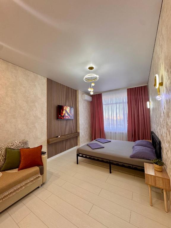 a bedroom with a large bed and a couch at A-Six Apartment, ЖК Достар 26 in Karagandy
