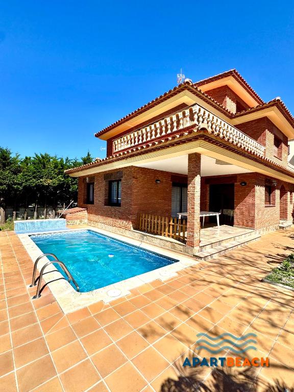 a house with a swimming pool in front of it at APARTBEACH BLAU MAR y PORT AVENTURA in Salou