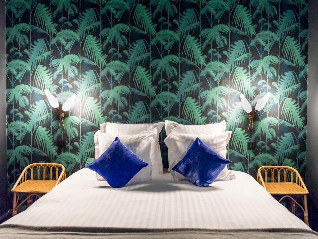 una camera da letto con un letto e carta da parati verde e bianca di 1er Etage SoPi-Montmartre a Parigi