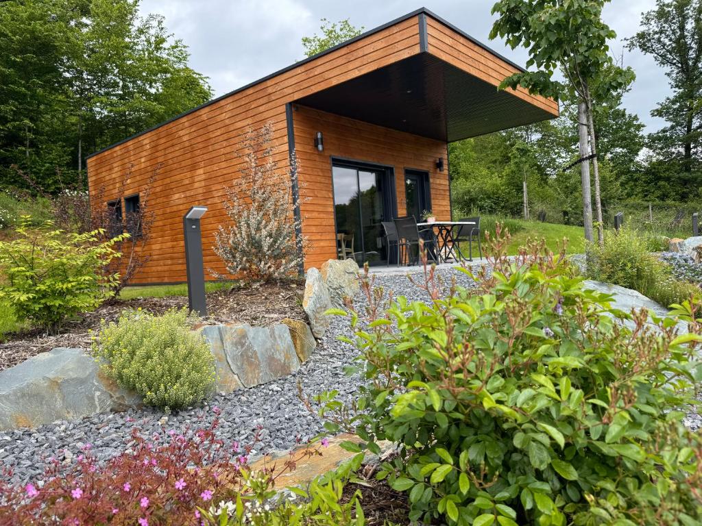a small wooden house in a garden at L'Orée Lodge in Montcornet