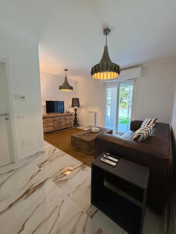 a living room with a couch and a table at Effealatapartments - L'Oasi del Forte in Forte dei Marmi
