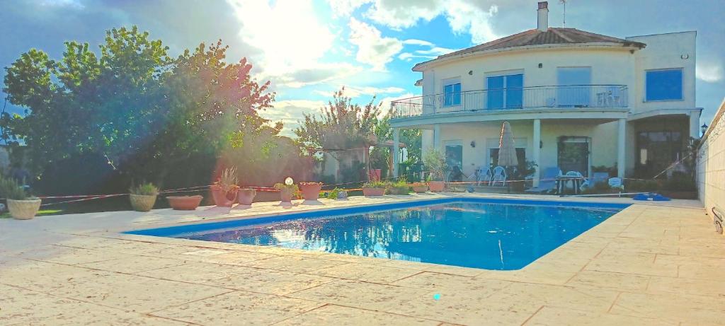 a large house with a swimming pool in front of it at CASA MIGUEL y SALLY in Villanueva de las Manzanas
