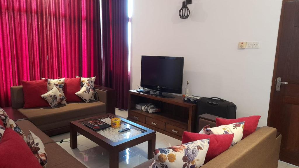 a living room with two couches and a tv at Be Cool in Aturugiriya