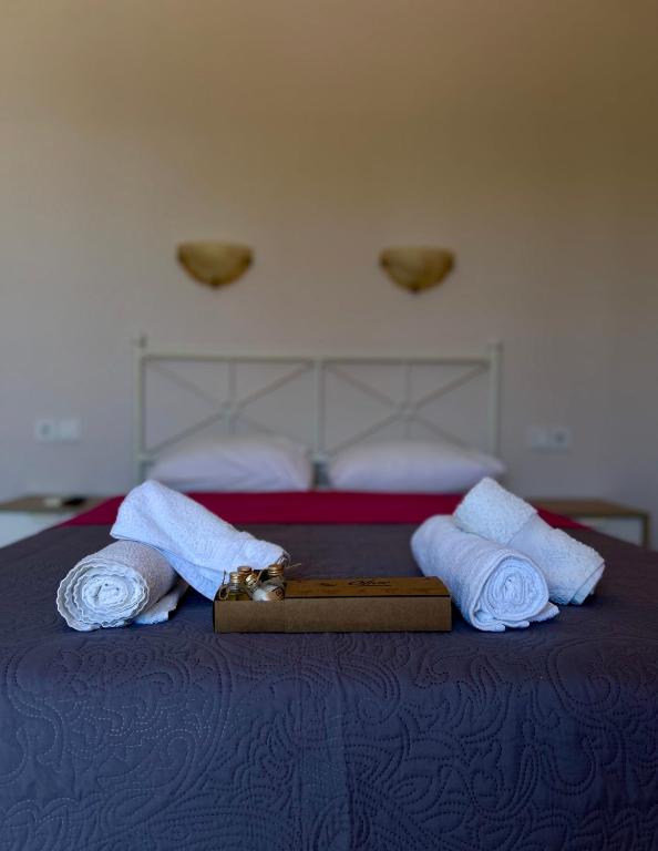 a bed with two towels and a box on it at Asprovalta Rooms in Asprovalta