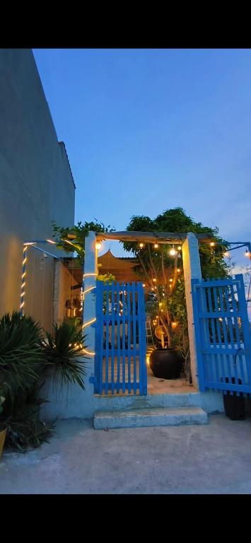 a blue gate in front of a building with lights at Homestay Nhà Có Gió in Thôn Mỹ Tường