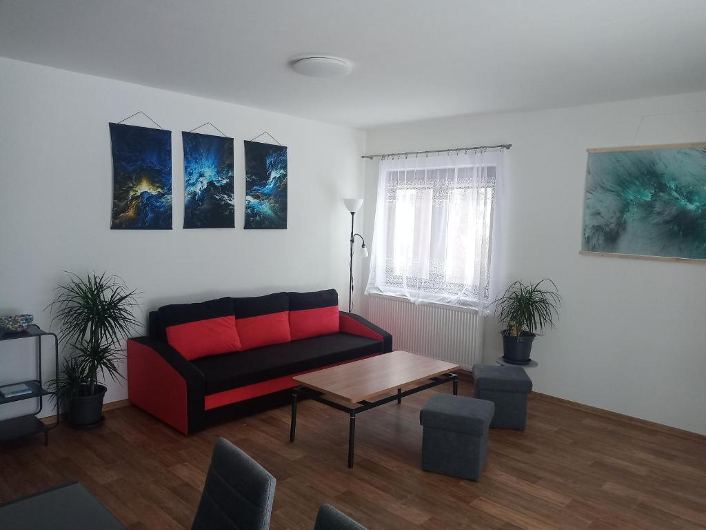 a living room with a red couch and a table at Apartmán Luby in Cheb