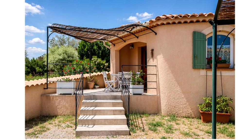 a house with a staircase leading to a porch at Gîte Valensole in Valensole