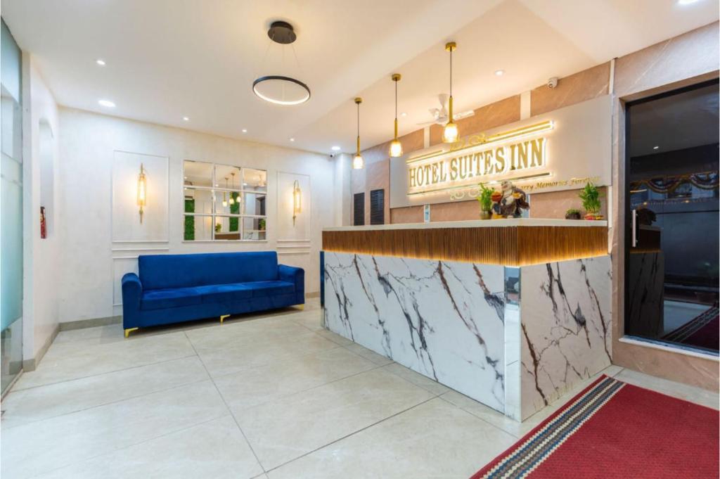 a lobby with a blue couch and a counter at Hotel Suites Inn in Mumbai
