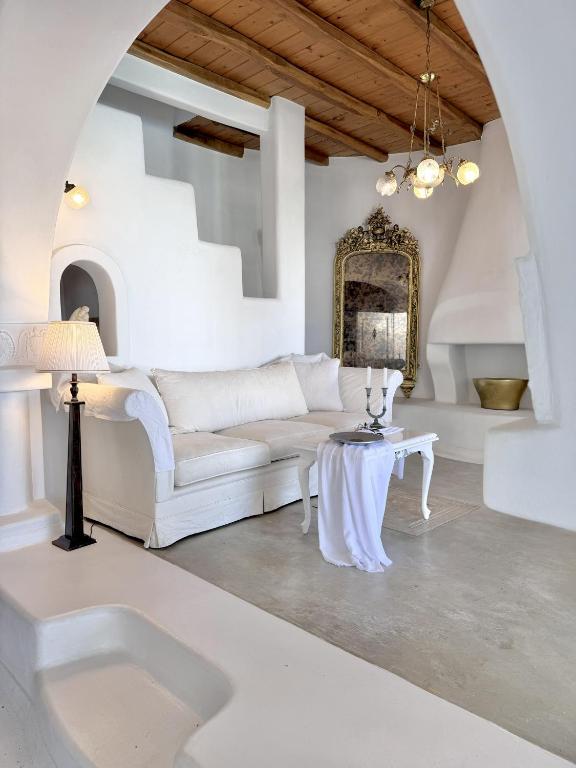 a living room with a white couch and a table at Villa ELAYA in Mikonos