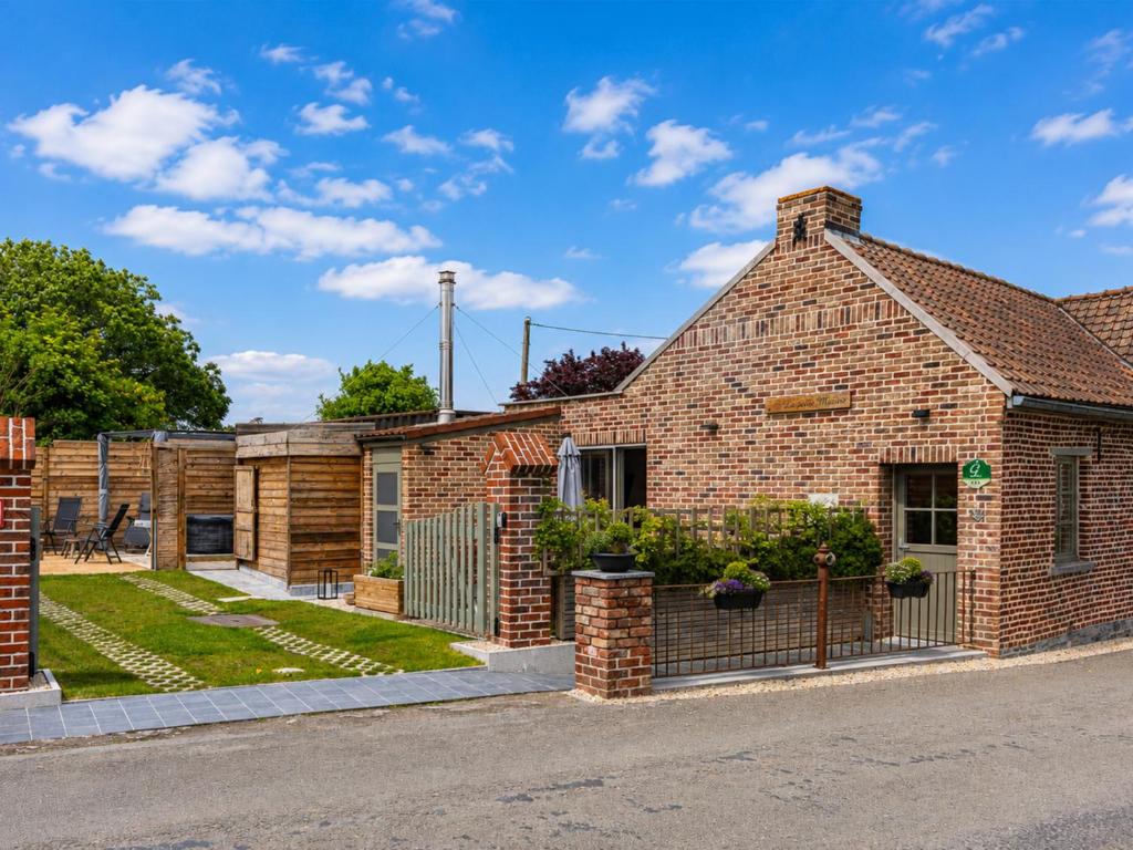 a brick house with a fence in front of it at La Petite Mazure in Tournai
