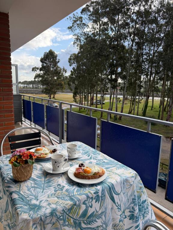 a table with two plates of food on a balcony at el AS del Puntal in Villaviciosa