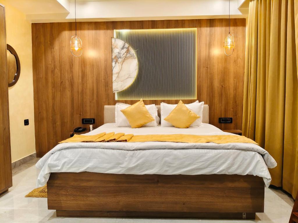 ein Schlafzimmer mit einem großen Bett und gelben Kissen in der Unterkunft HOTEL ABHIJIt in Kolaghat