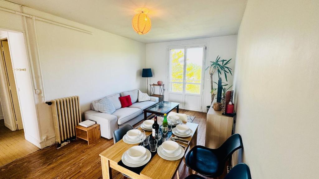 a living room with a couch and a table at Les hauteurs d'Avon - Vue forêt - Parking in Avon
