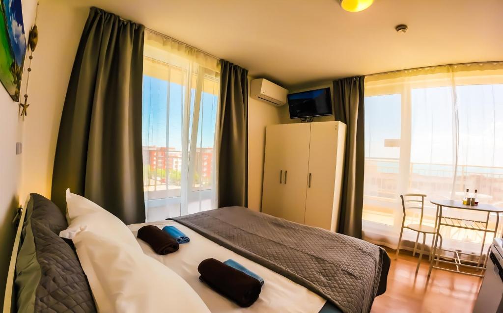 a bedroom with a large bed with a table and a window at William's apartments - second cozy studio in Sveti Vlas