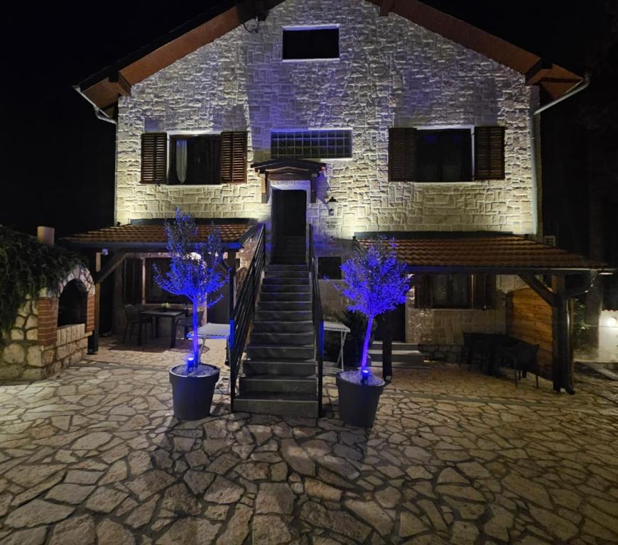 a building with three blue trees in front of it at Villa Forko Luxury Spa Near Paradise Beach in Lopar