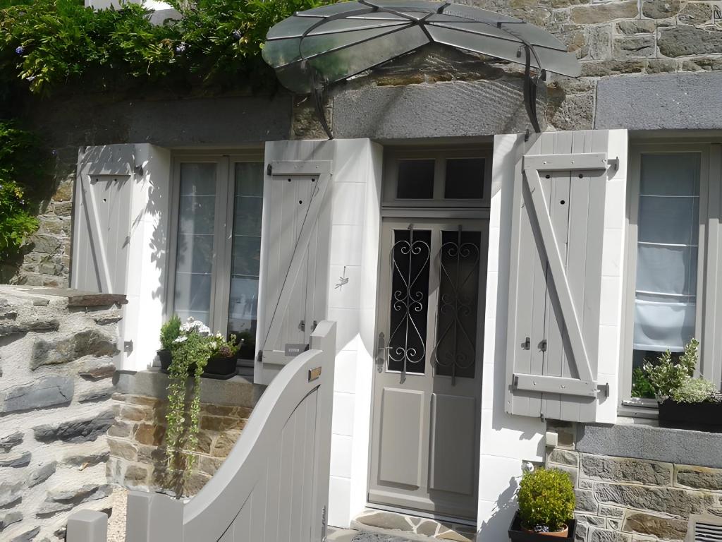a house with a white door and an umbrella at Rêves d'Emeraude in Cancale