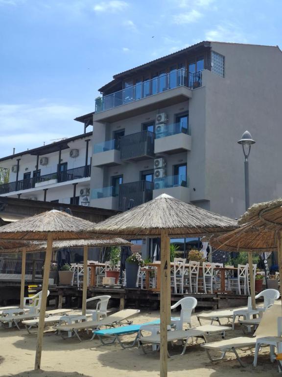 a group of chairs and umbrellas in front of a building at Olympic Hotel in Olympiada