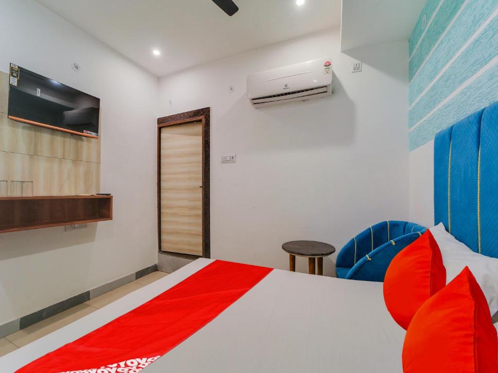 a bedroom with a bed with red pillows at Hotel O Jagdamba Hotel in Bhopal