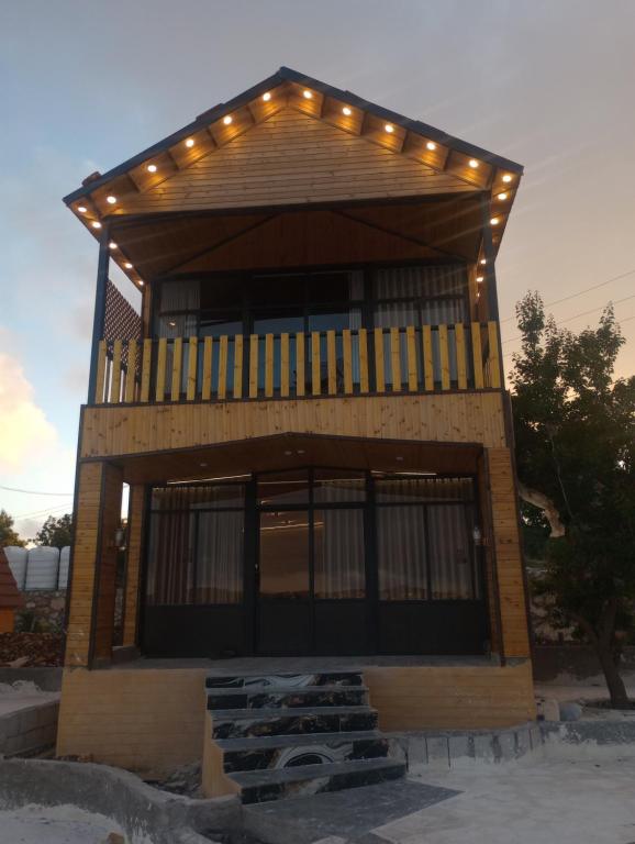 a building with a balcony with lights on it at اكواخ السوسنة السوداء in Ajloun