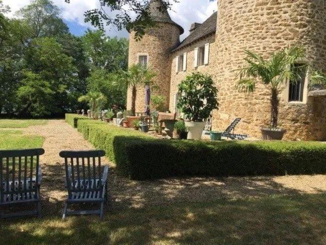 a group of benches sitting in front of a building at Chateau de Lestang in Savignac