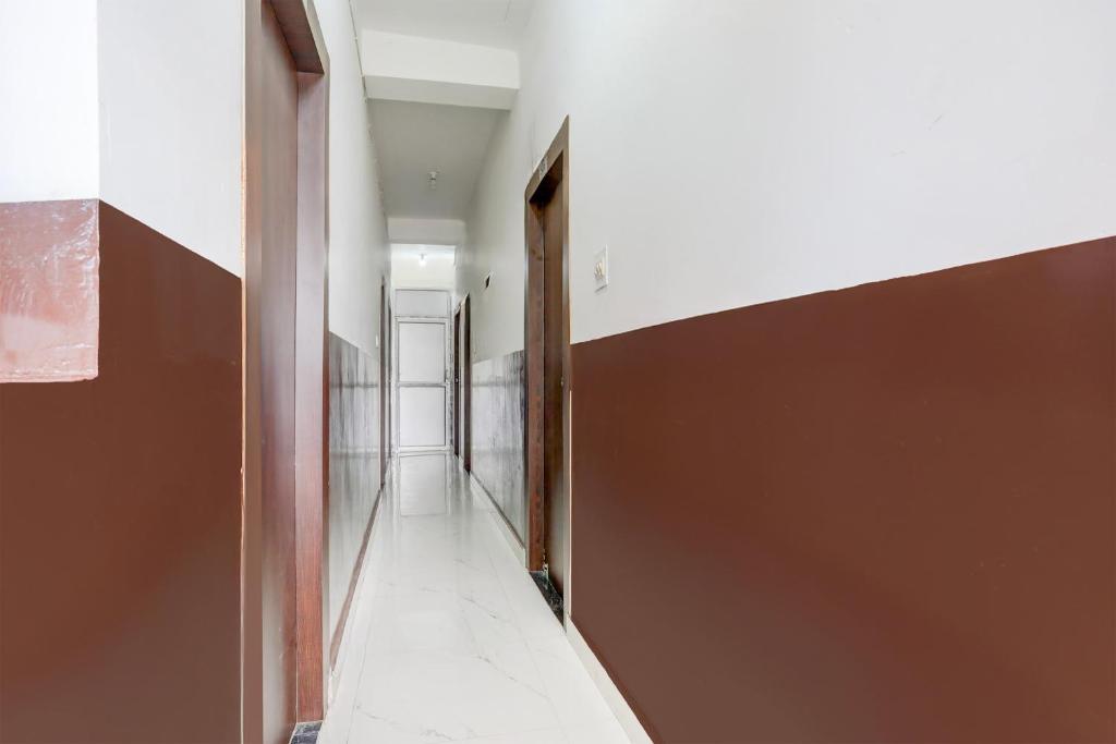 a hallway with a brown and white wall at Hotel O Kings Hotel & Banquet in Siliguri