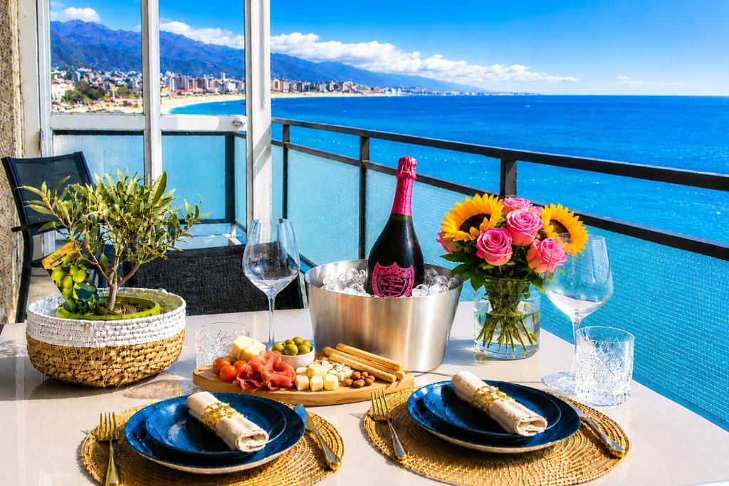 a table with a bottle of wine and food on a balcony at You and the Sea in Savona